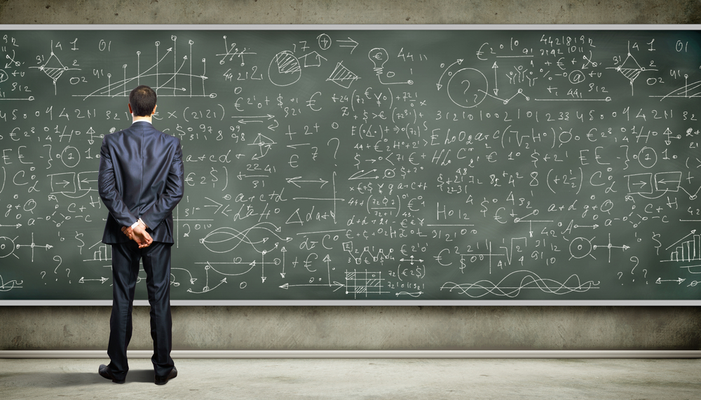 Business person standing against the blackboard with a lot of data written on it Business person standing against the blackboard with a lot of data written on it